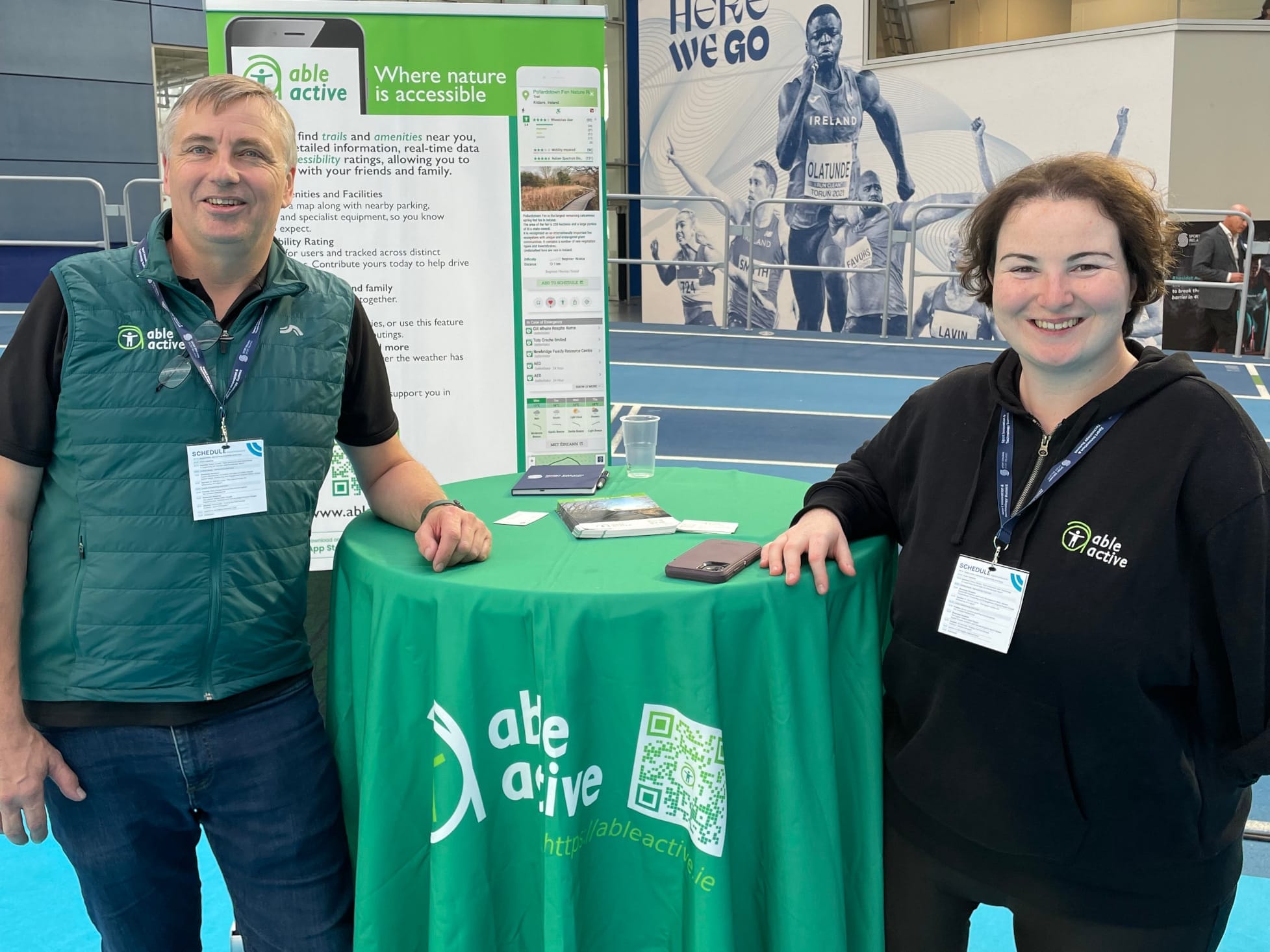 Adrian Geissel and Sarah Kerrigan at an exhibitor table draped in the Able Active branded tablecloth