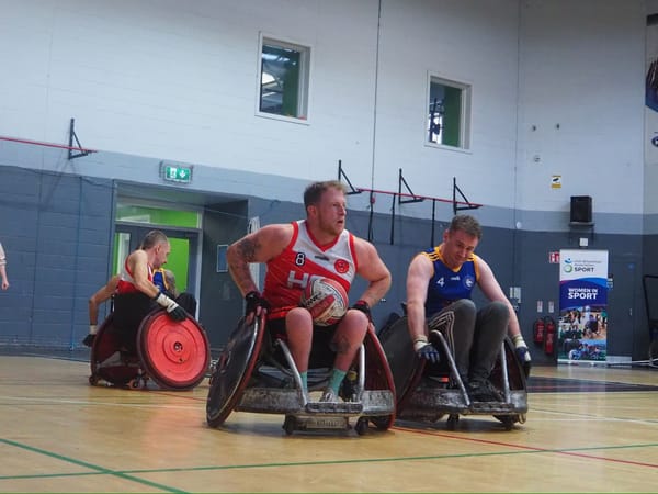 Photo of Jack Squibb playing wheelchair rugby in a sports hall