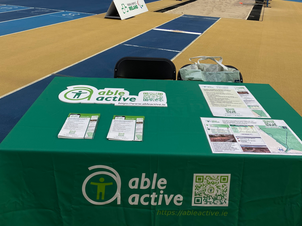 Exhibitor table with branded tablecloth and flyers at the Sport Ireland National Indoor Arena